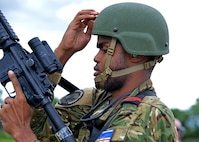 Cabo-Adjunto Ravidson Vezo Lopes of the Cabo Verdean Armed Forces and Master Cpl. Lisa Leopold of the Canadian Armed Forces fist bump after a pistol match at the 2024 New Hampshire National Guard Combat Marksmanship Match on June 8 at Fort Devens, Mass.