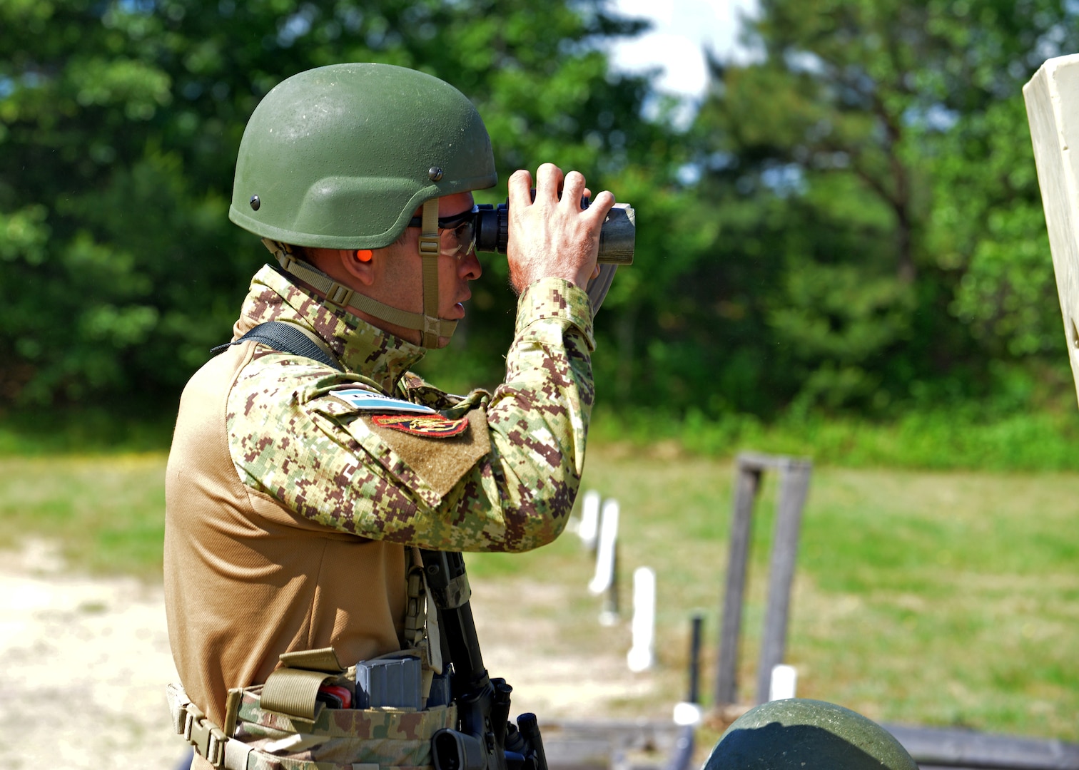 Stte. Inf. Jaime Eduardo Peraza Orantes spots targets downrange as his Team El Salvador teammates shoot the “Know Your Limits” rifle course at the 2024 New Hampshire National Guard Combat Marksmanship Match on June 8 at Fort Devens, Mass. His four-person team successfully defended its championship from last year, besting a field of 21 squads.