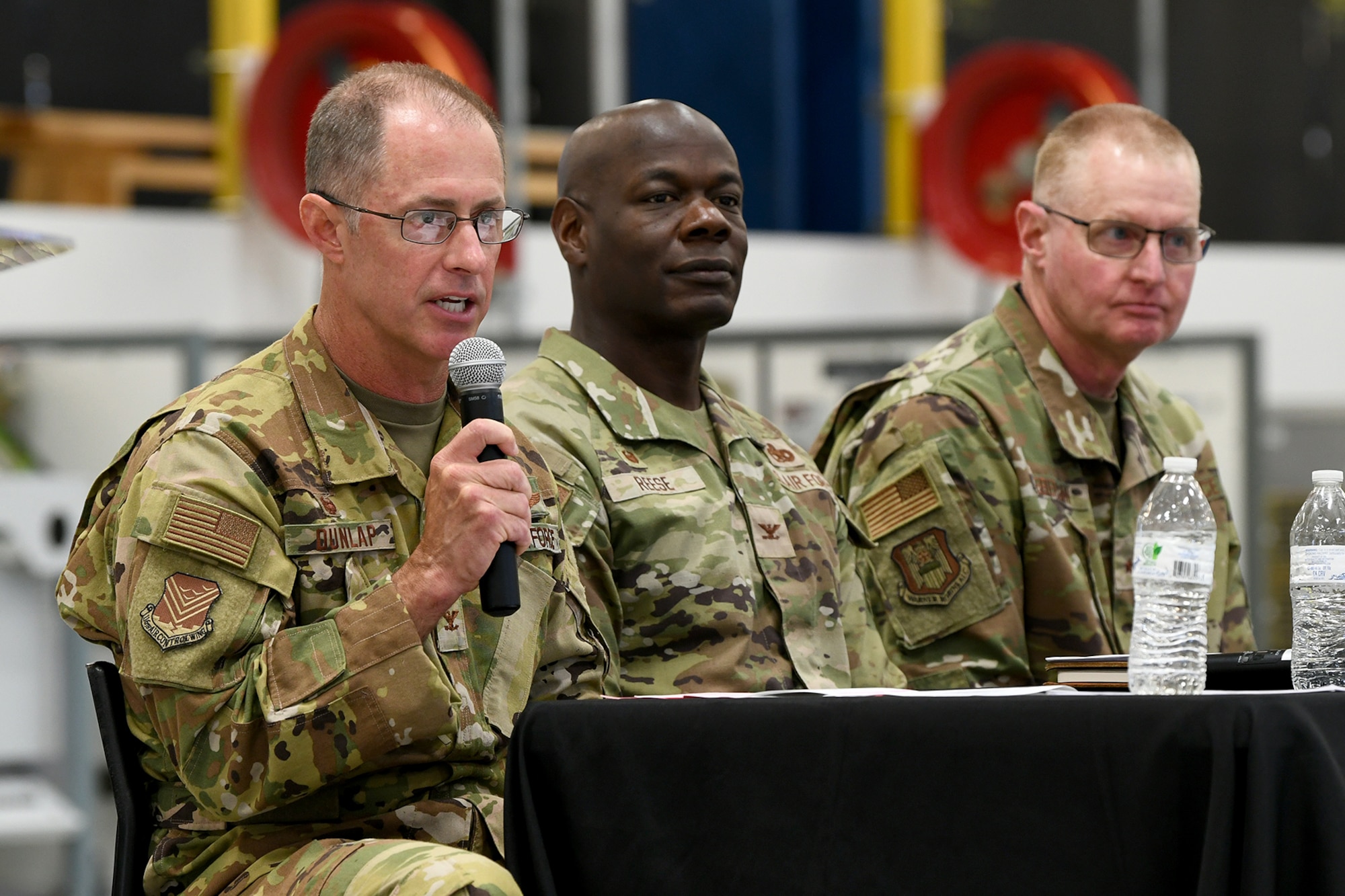 Three men in military uniform sitting at a table