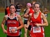 Christina O'Brian (L) and Victoria Rollin run in a cross-country competition.