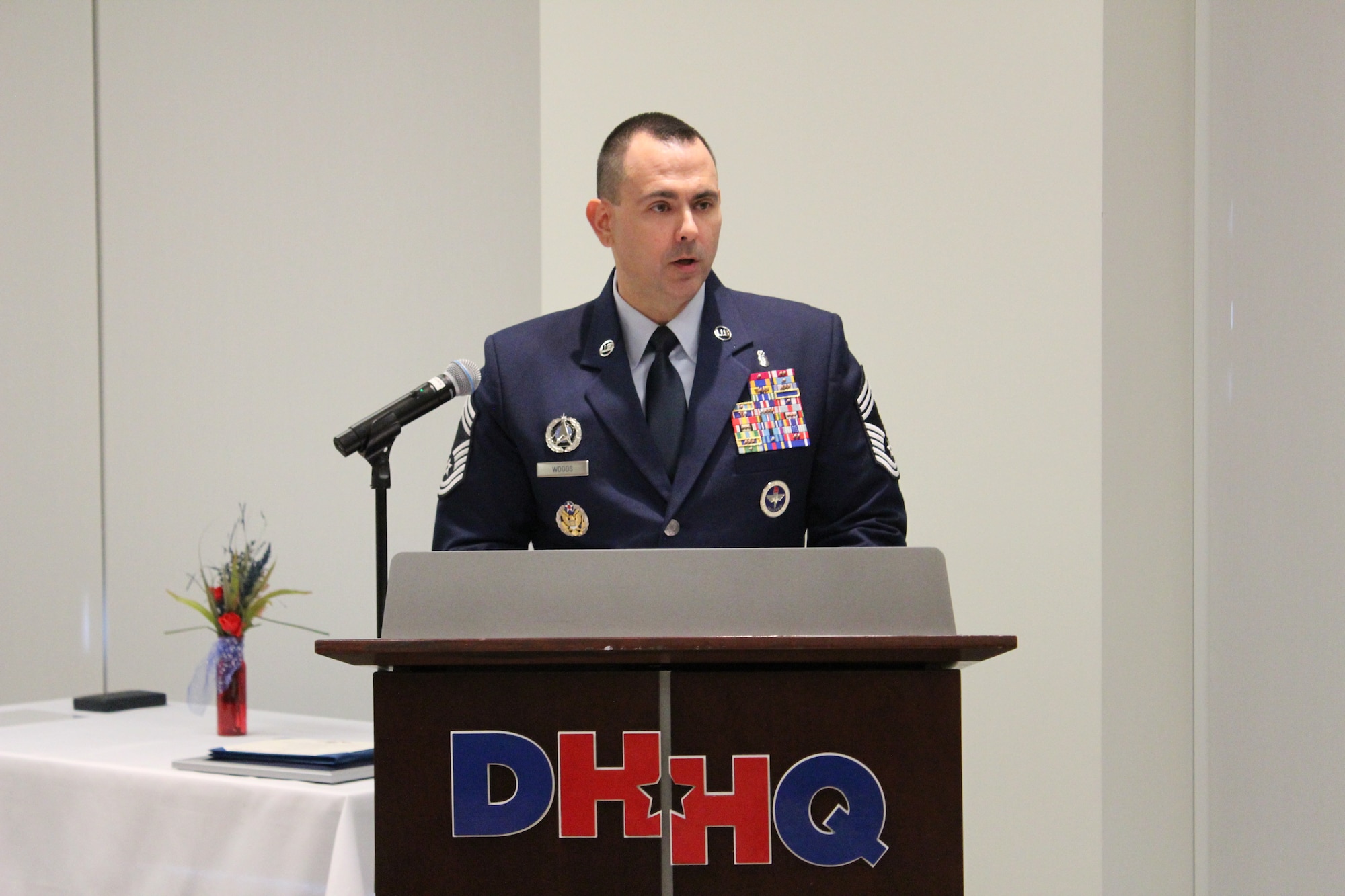 Image of an Airman talking at a podium.