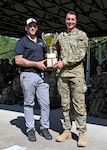 Sgt. 1st Class Joe Wyner, state marksmanship coordinator, New Hampshire Army National Guard, left, presents Capt. Robert Matzelle, commander of Charlie Company, 3rd Battalion, 172nd Infantry Regiment (Mountain), with the first-place trophy as the 2024 New Hampshire National Guard Combat Marksmanship Match individual champion June 8, 2024. Matzelle defended his title from last year as the match’s top shot, placing first out of 90 competitors.