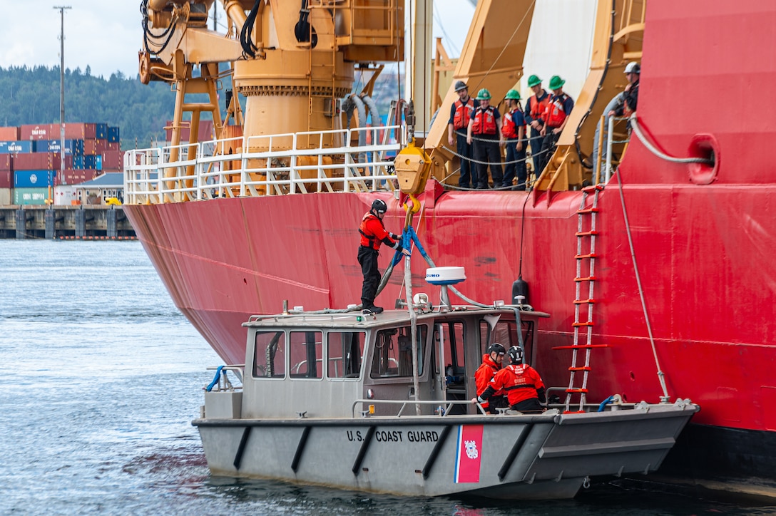 Coast Guard Cutter Healy (WAGB 20) crewmembers prepare to hoist the cutter's small boat before departing Seattle for their annual Arctic deployment, June 12, 2024. The Healy is America's largest polar ice breaker and explicitly designed to support Arctic research. (U.S. Coast Guard photo by Petty Officer 3rd Class Annika Hirschler)