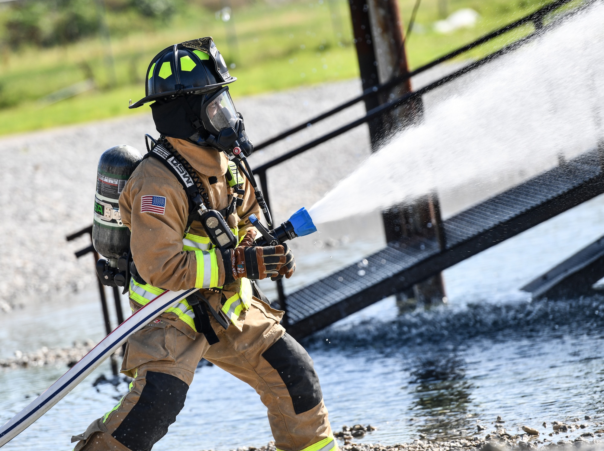 firefighter sprays fire hose