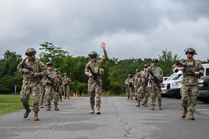 Men and women in uniform walk in a formation.
