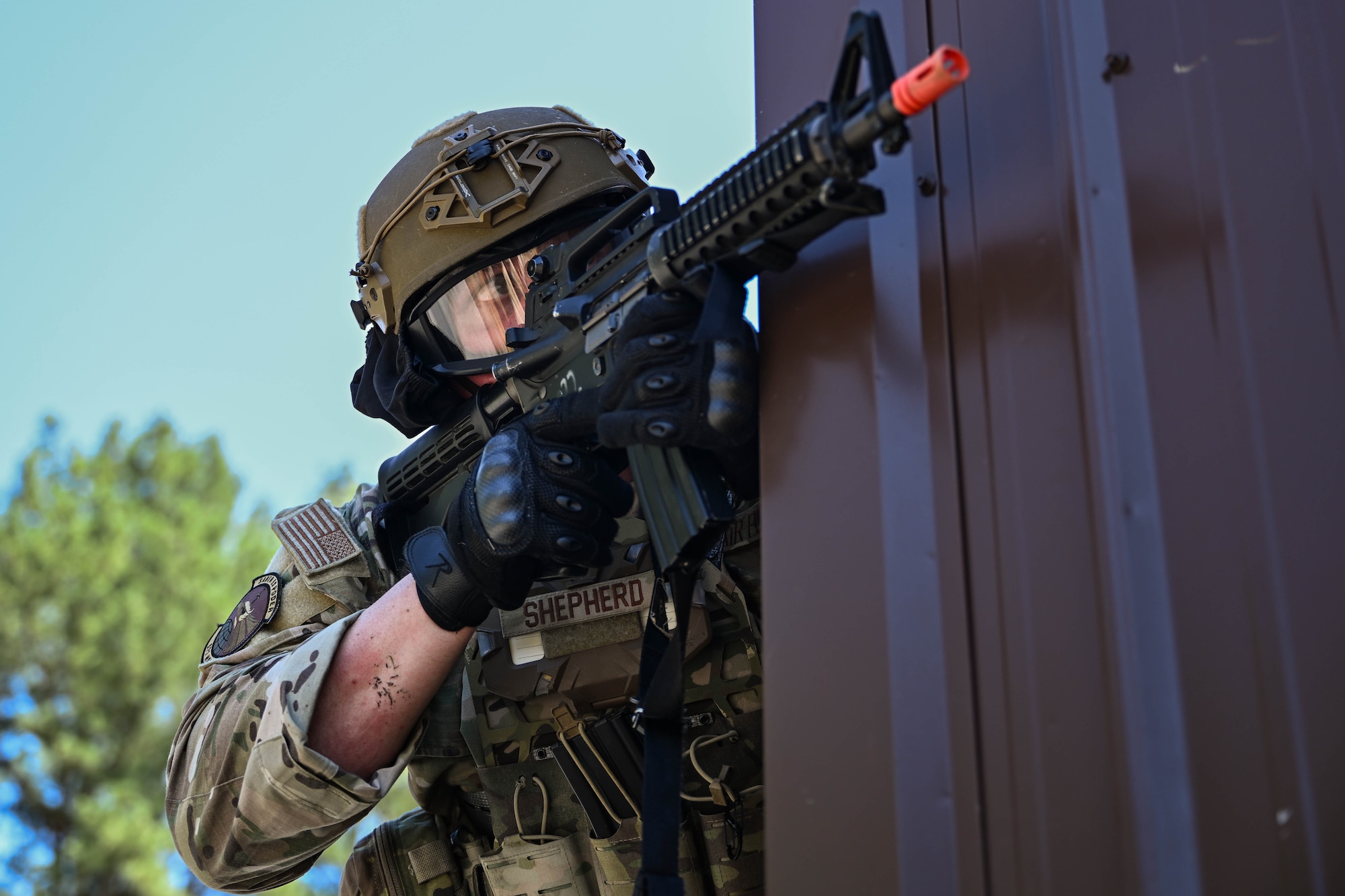 A man in uniform aims an airsoft weapon.