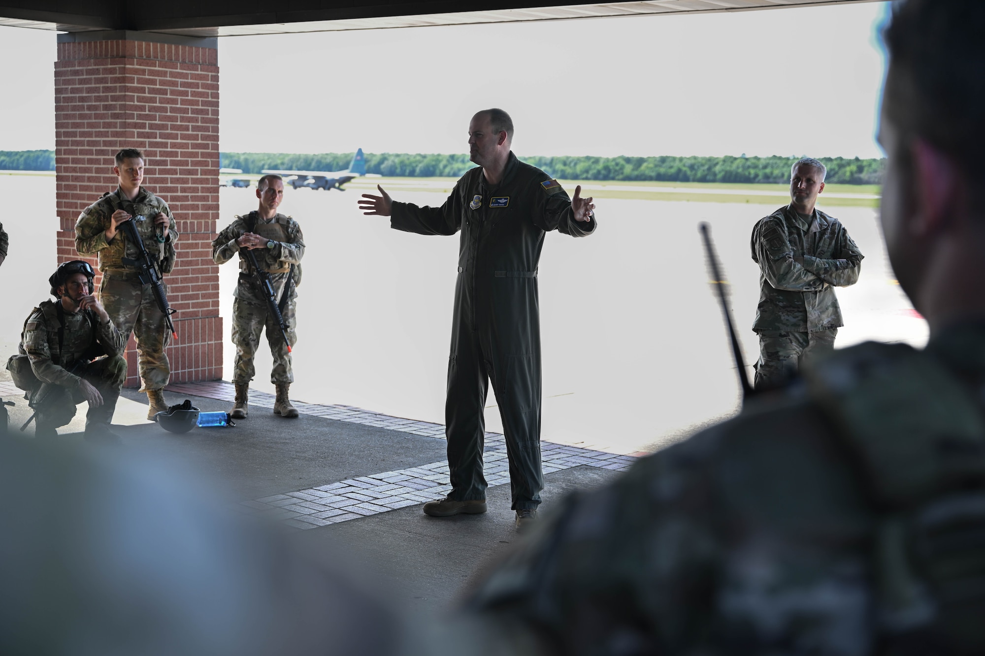 A man in uniform speaks to a group of people in uniform.