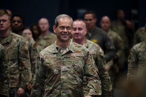 Gen. Ken Wilsbach walks down the aisle in the base theater.
