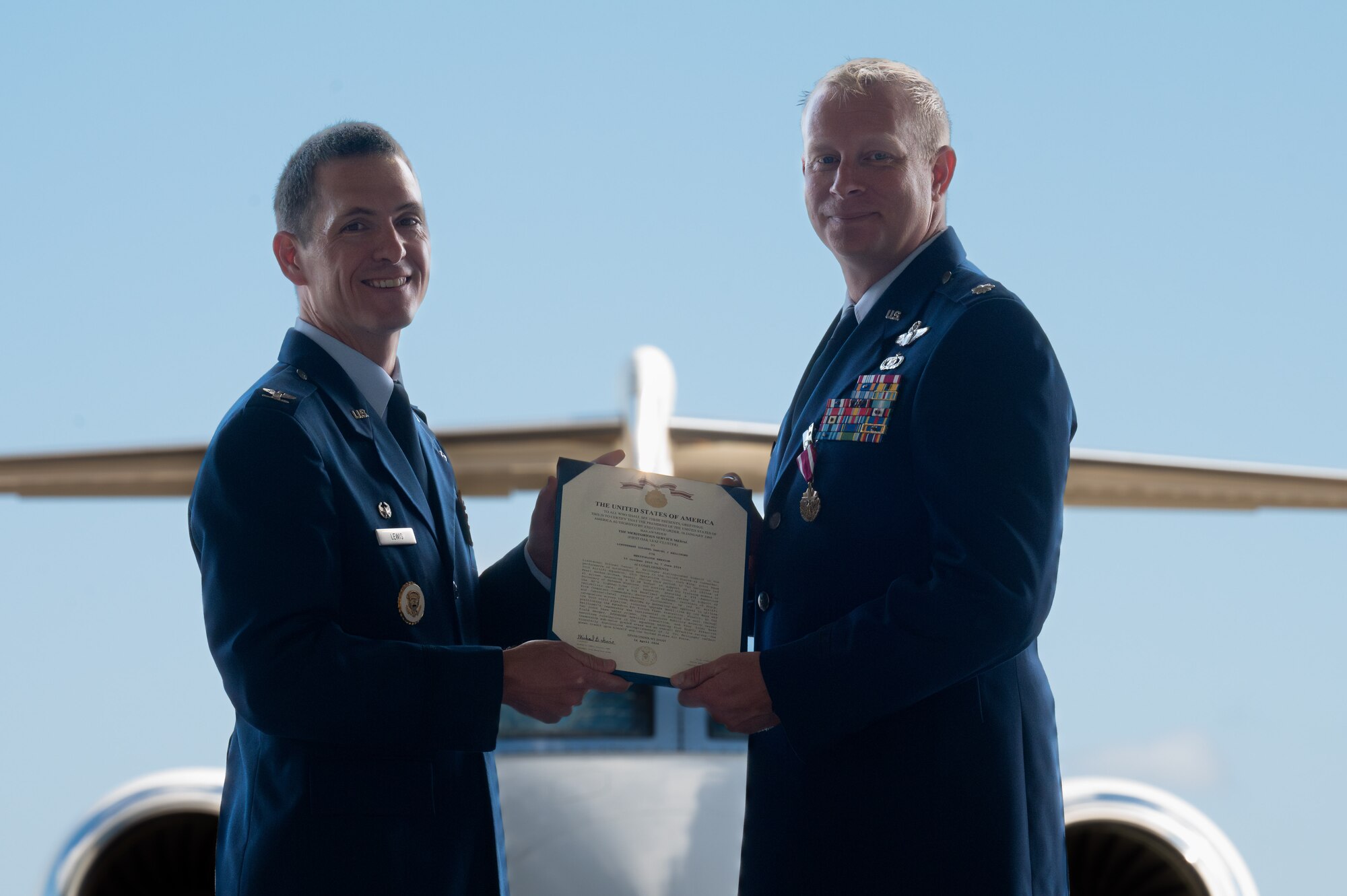 Airmen hold military citation for service as commander.