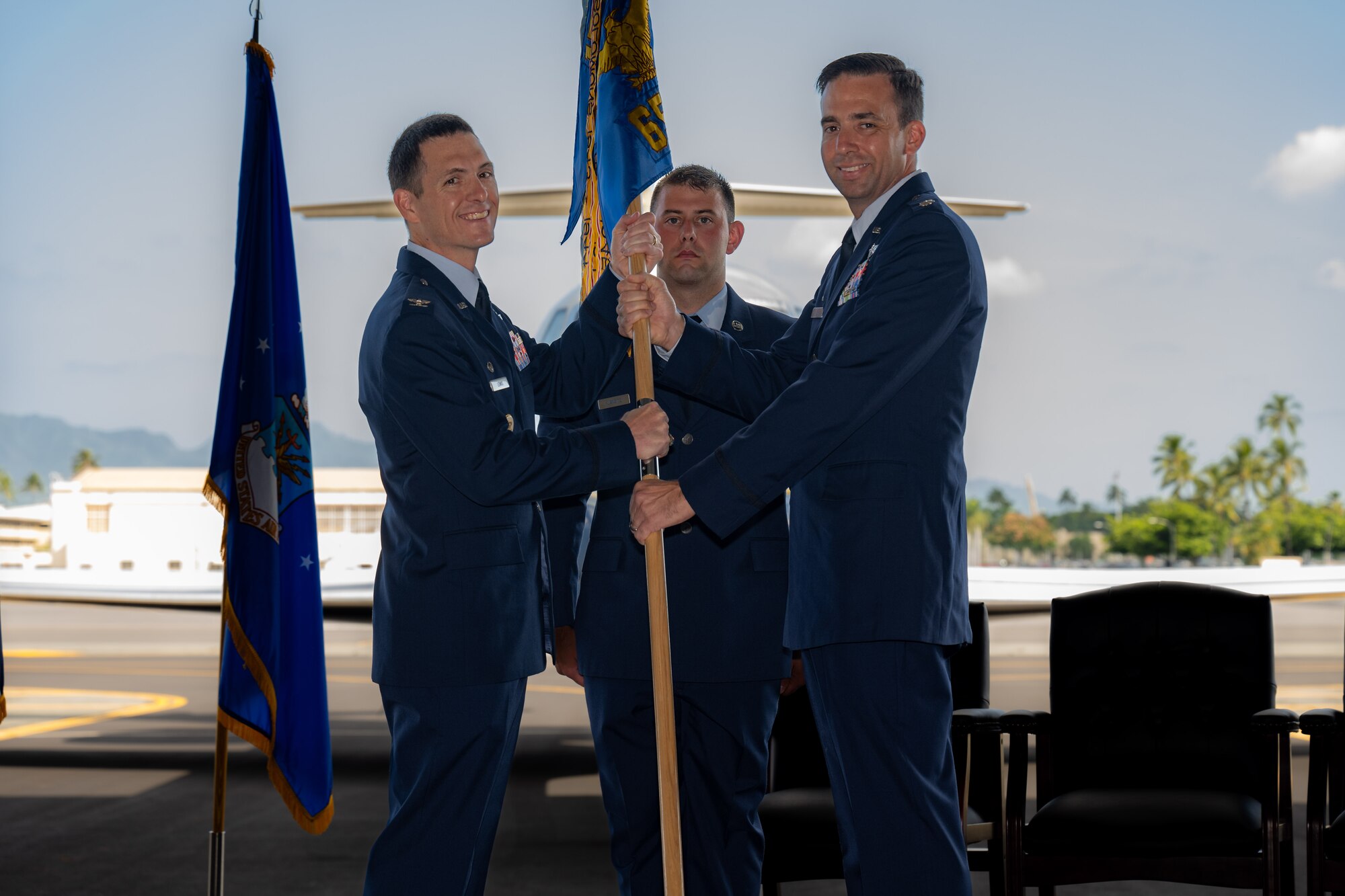 Airmen hold guidon during a change of command ceremony.