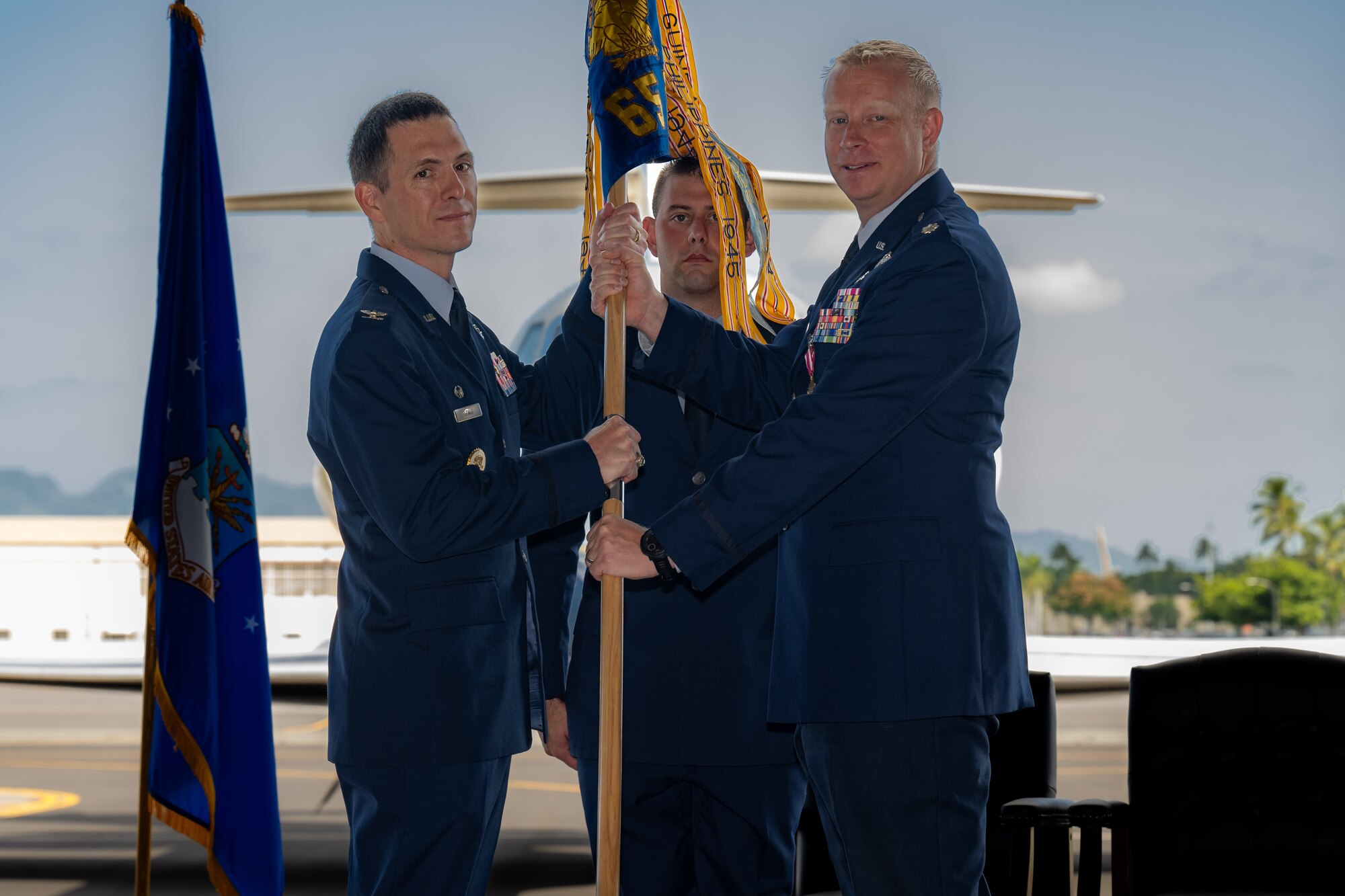 two airmen hold a guidon.