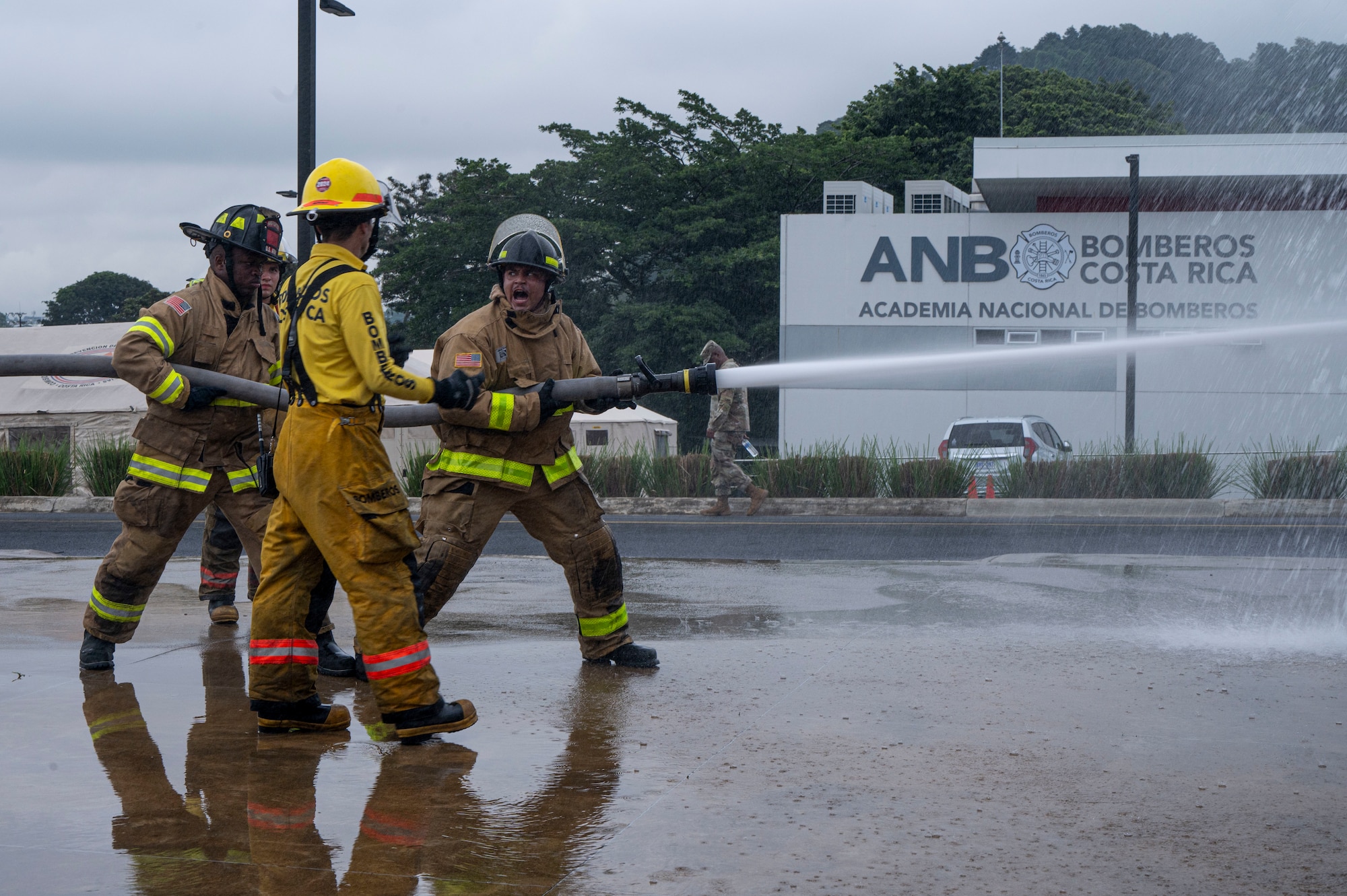 A photo of firefighters spraying a hose together.