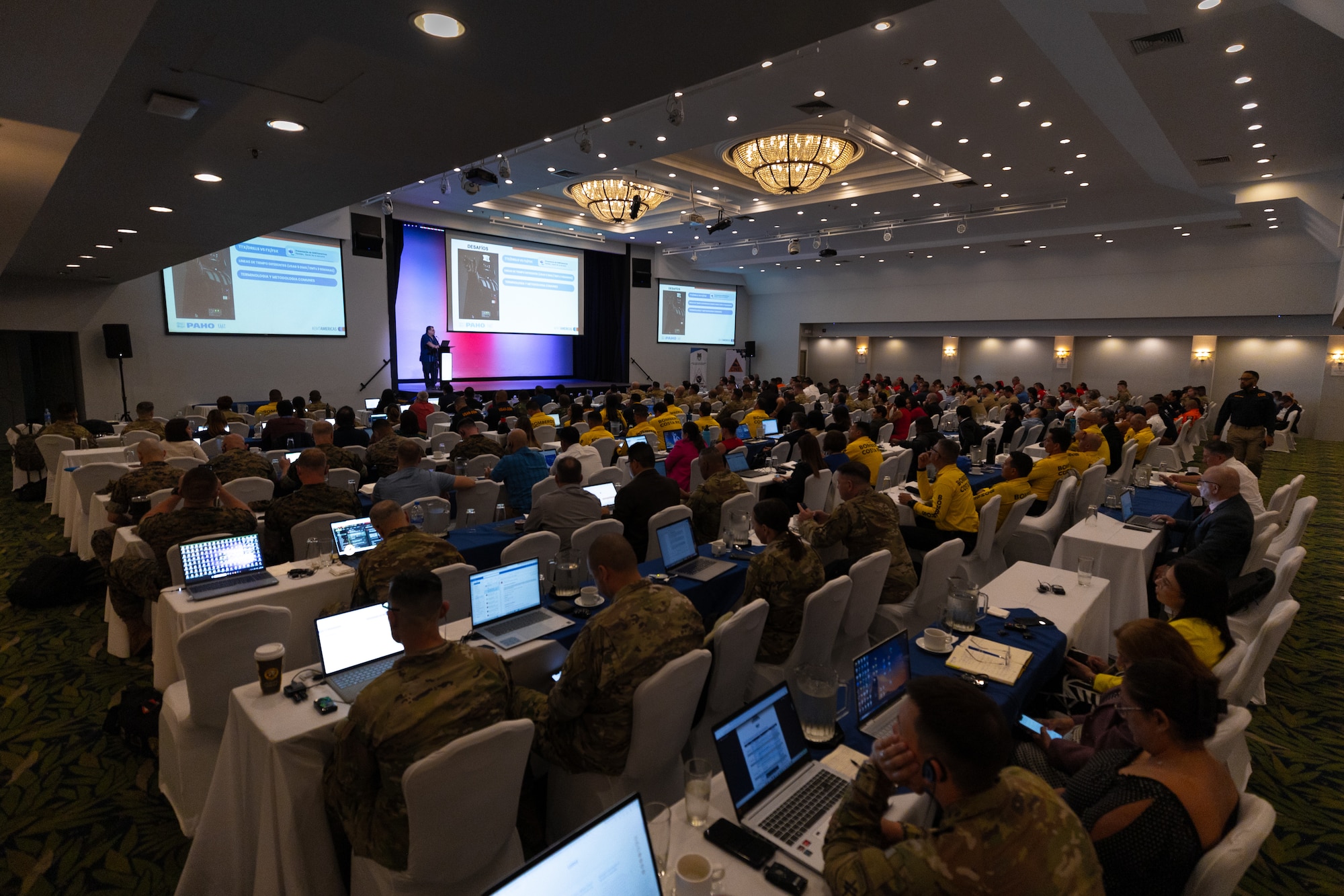 A photo of a large crowd listening to a presentation.