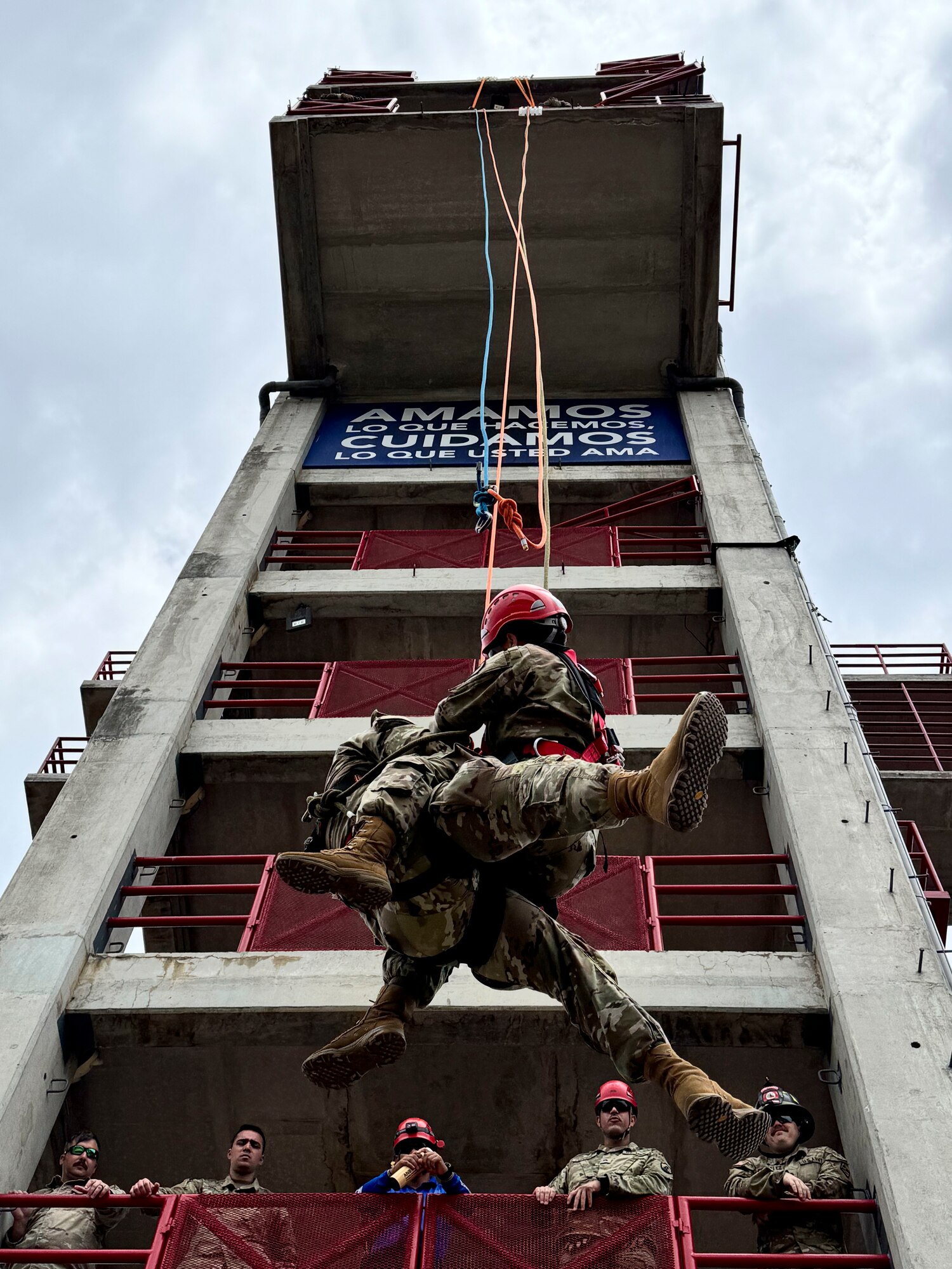A photo of people repelling off a structure.