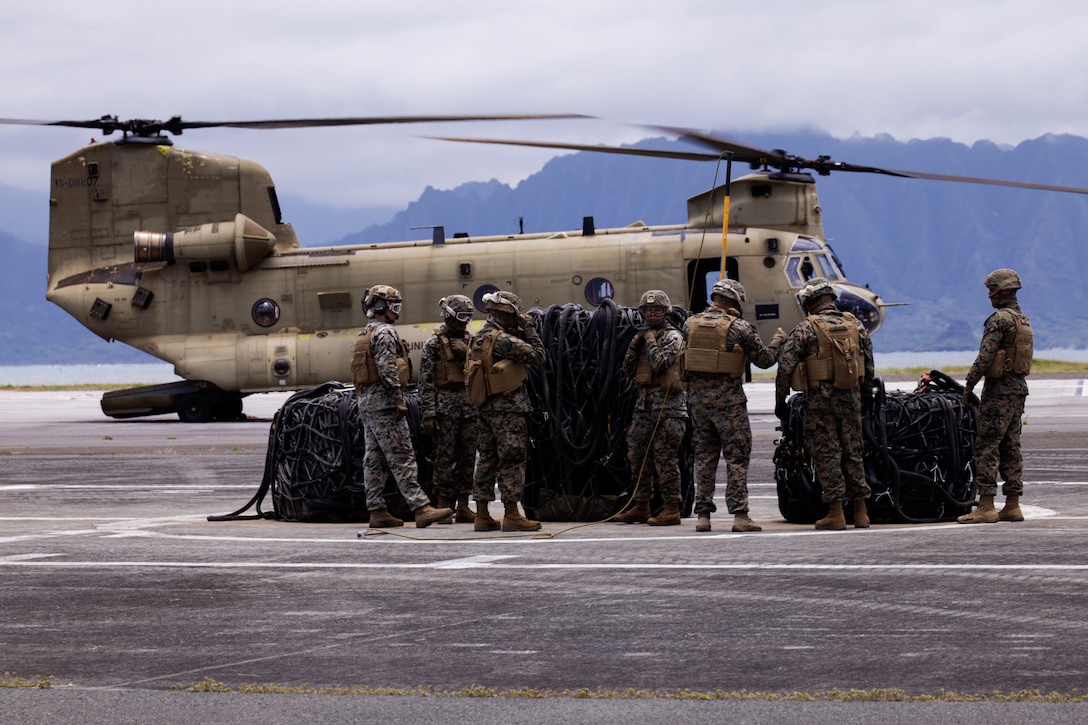 U.S. Marines with Combat Logistics Company 33, 3rd Marine Logistics Group, 3rd Marine Expeditionary Force, prepare for an external lift operations exercise at Marine Corps Air Station Kaneohe Bay, Marine Corps Base Hawaii, June 6, 2024. Marines and Soldiers collaborated in an external lift operations exercise, bolstering efficiency in airlifting oversized cargo while offering a distinctive cross-training opportunity. (U.S. Marine Corps photo by Lance Cpl. Carlos Daniel Chavez-Flores)