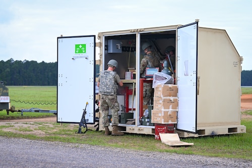 Military members working inside a equipment container.