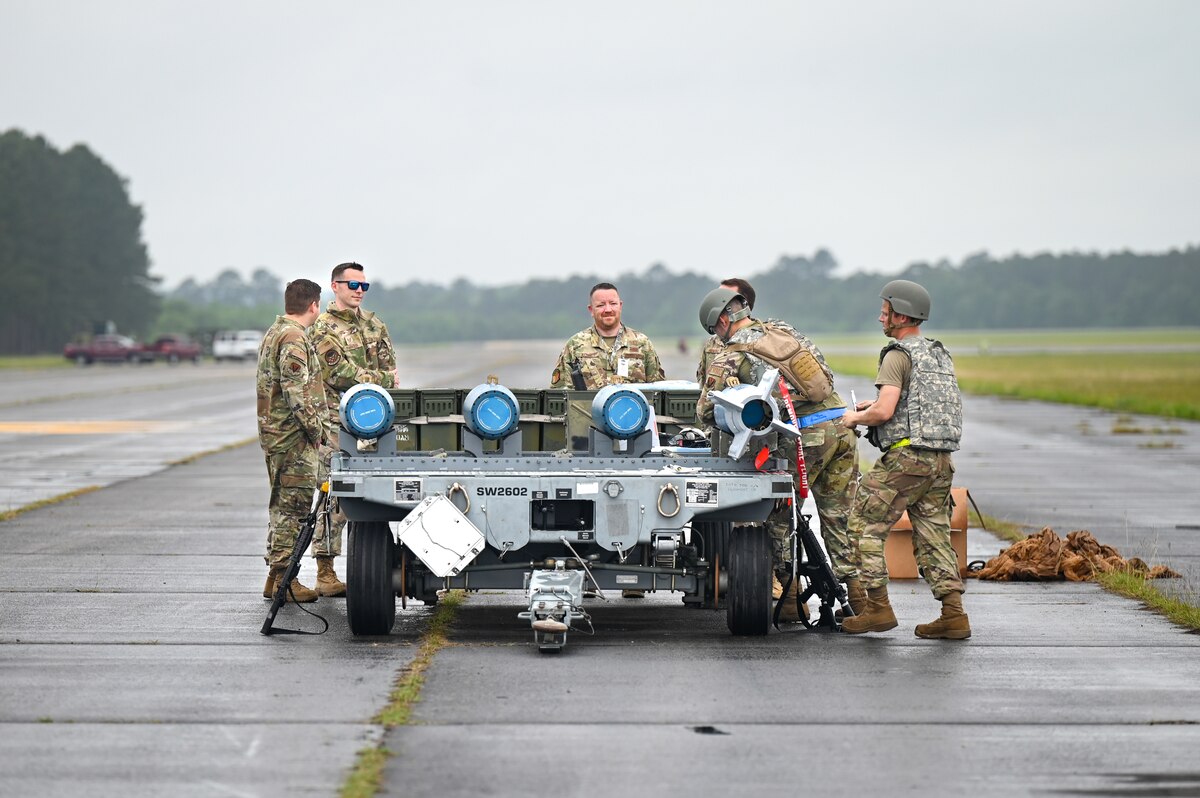 Six military members working on building munitions.