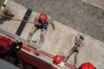 A photo of people repelling off a structure.
