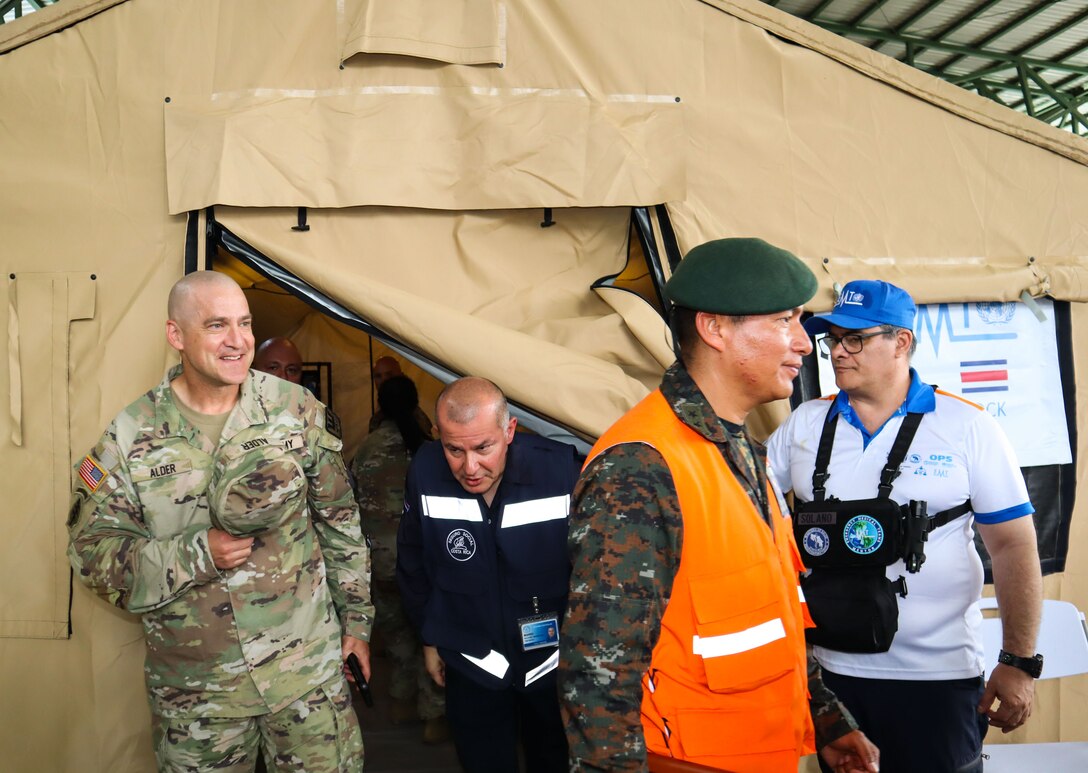 A photo of service members walking out a tent.