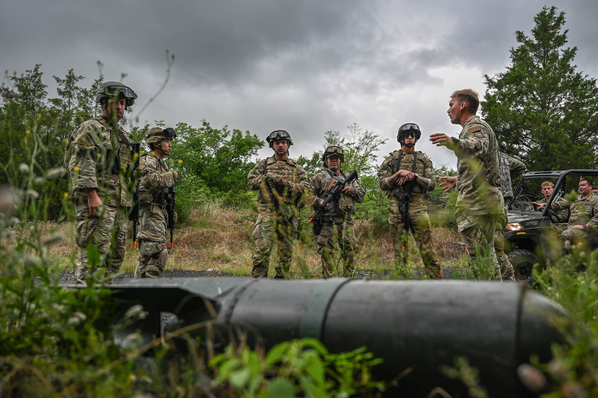 Men in uniform surround a simulated explosive.