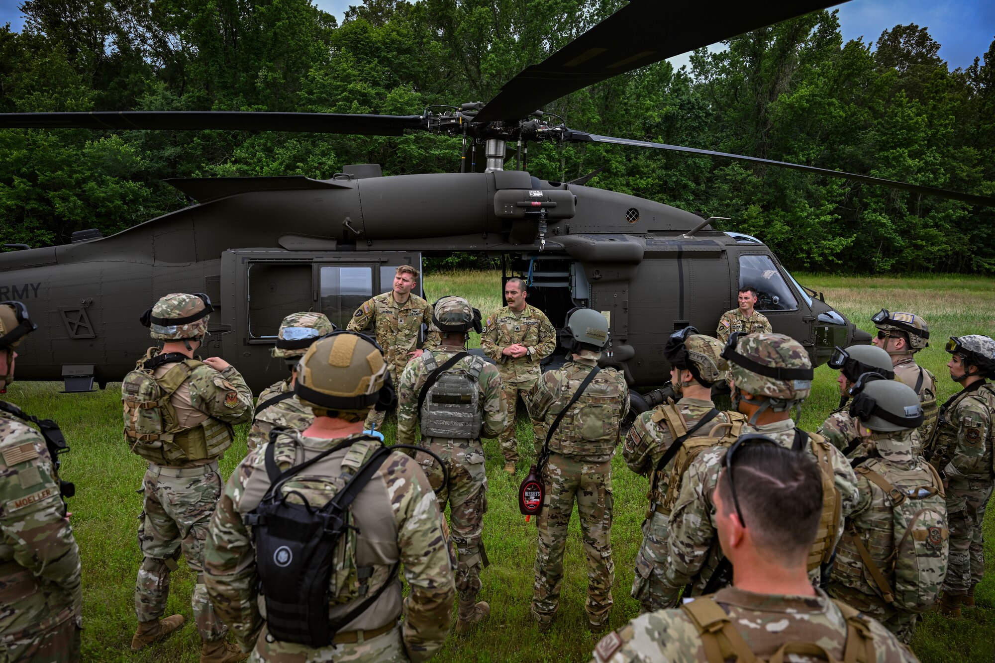 A group of people in uniform surround a helicopter.