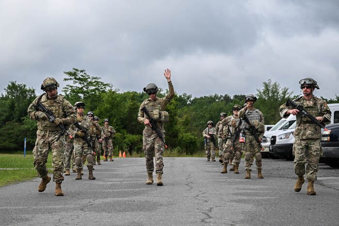 Men and women in uniform walk in a formation.