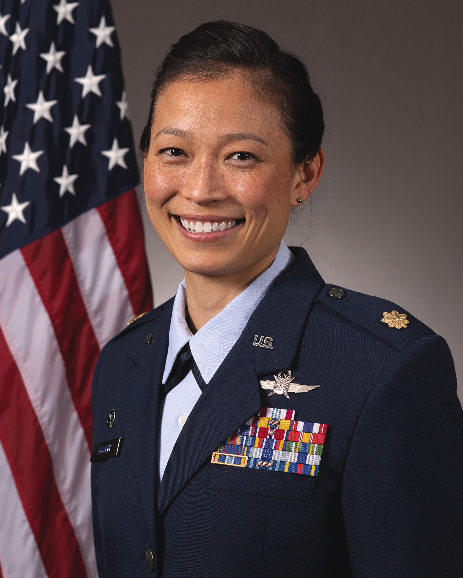 photo of uniformed U.S. Air Force Airmen standing in front of U.S. flag