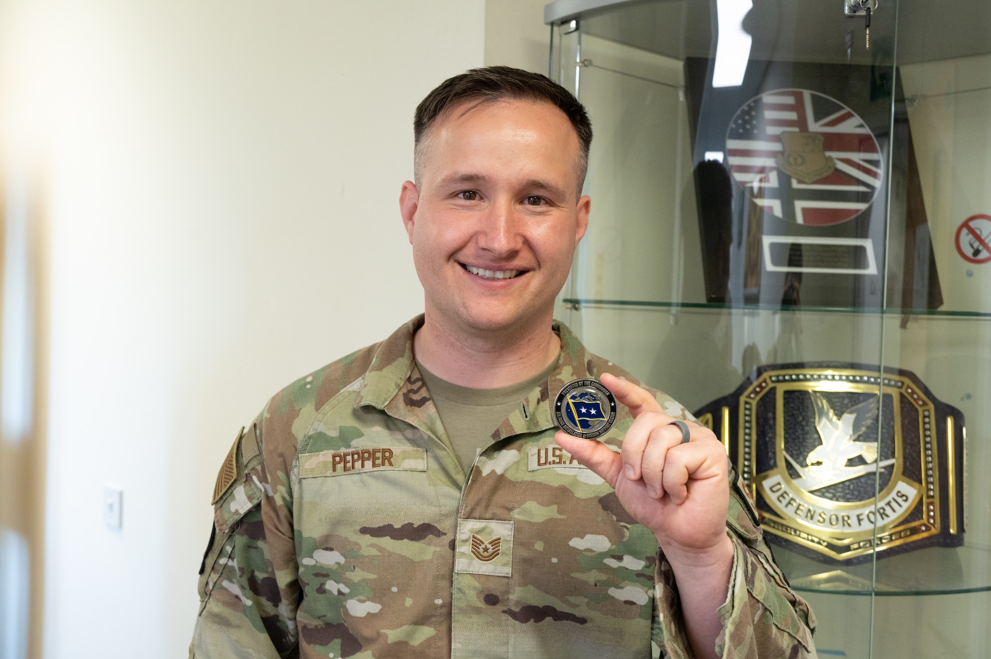 U.S. Air Force Tech. Sgt. Chance A. Pepper, 420th Security Forces senior enlisted leader poses with the coin he received from Maj. Gen. John J. Allen Jr.