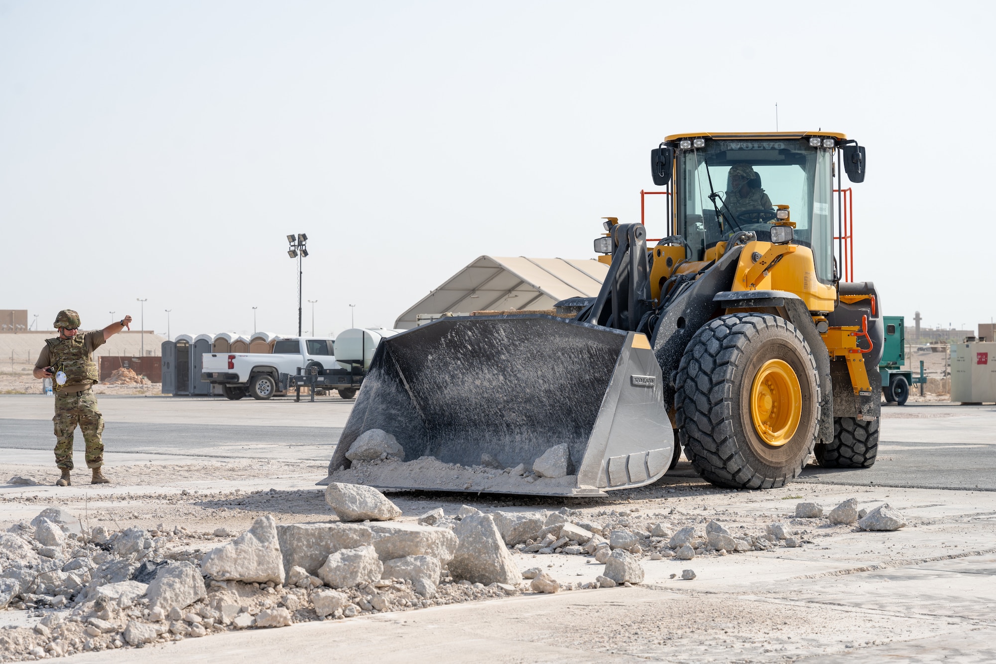 An Airman assigned to the 379th Expeditionary Civil Engineer Squadron directs a bulldozer to rubble during a Rapid Airfield Damage Repair exercise at an undisclosed location within the U.S. Central Command area of responsibility, June 12, 2024.