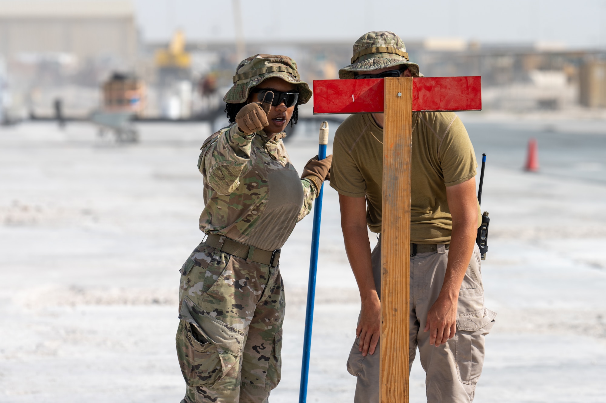 Airmen assigned to the 379th Expeditionary Civil Engineer Squadron use a measuring tool during a Rapid Airfield Damage Repair exercise at an undisclosed location within the U.S. Central Command area of responsibility, June 12, 2024.
