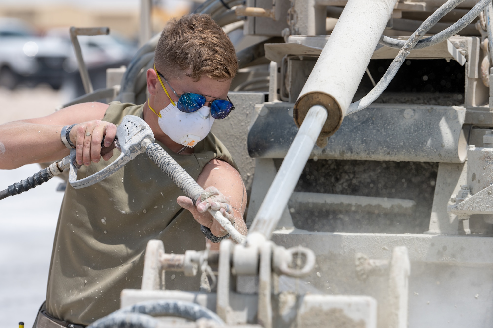 An Airman assigned to the 379th Expeditionary Civil Engineer Squadron adds water to a concrete mix during a Rapid Airfield Damage Repair exercise at an undisclosed location within the U.S. Central Command area of responsibility, June 12, 2024.