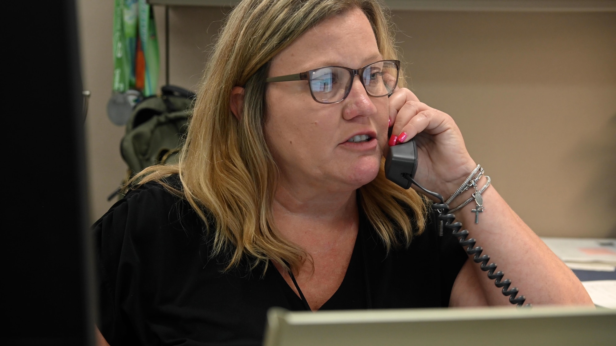 Lisa Barclay, customer service unit lead answers phone at Maxwell Air Force Base, Ala. June 6, 2024. Handling between 1,300 to 1,500 work orders monthly, the Civil Engineering squadron is vital for maintaining Maxwell and Gunter Annex. These bases host various professional military education schools, requiring top-tier infrastructure efficiency.