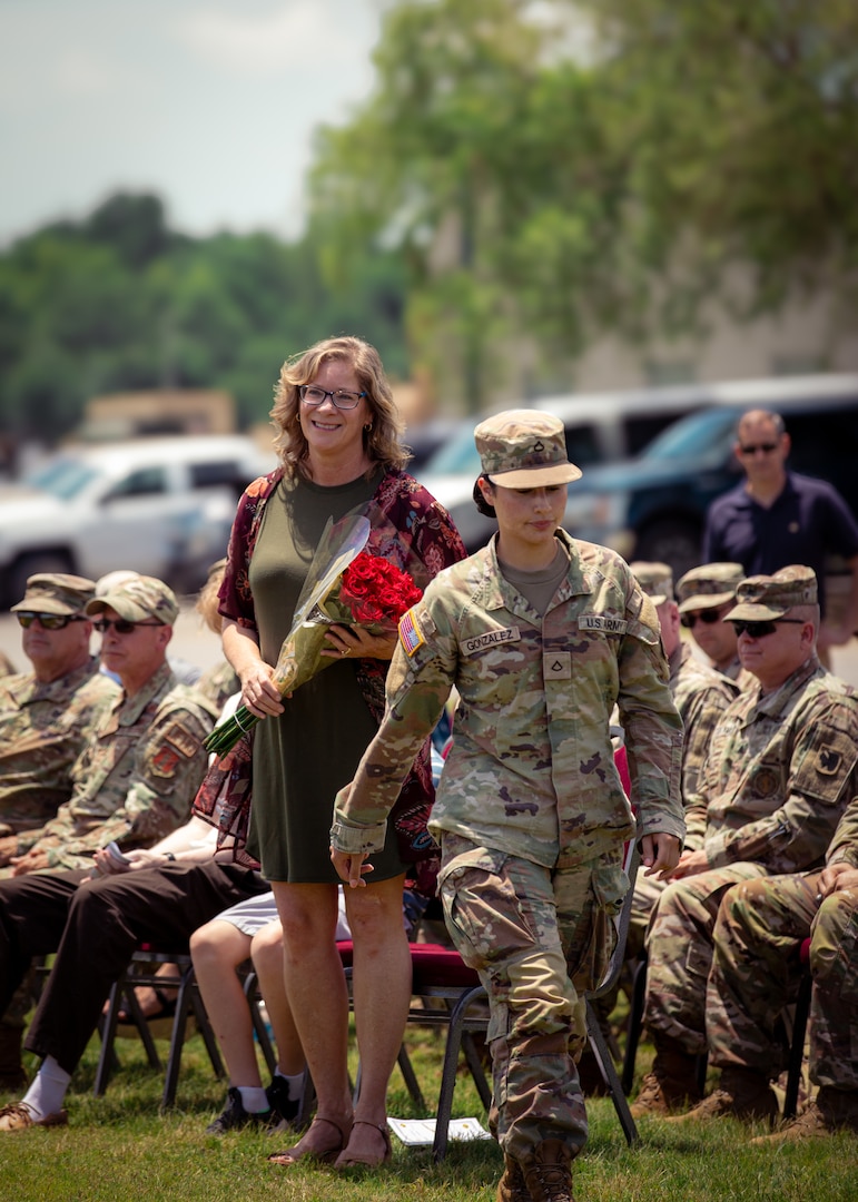 Bridget Ballenger, wife of Col. Andrew Ballenger, outgoing commander for the Oklahoma Army National Guard’s 45th Infantry Brigade Combat Team, receives a bouquet of roses during a change of command ceremony between Ballenger and Col. Khalid Hussein, incoming commander for the 45th IBCT held at the Camp Gruber Training Center near Braggs, Oklahoma, June 11, 2024. Ballenger commanded the 45th IBCT since August 2022, leading the brigade through numerous deployments and training exercises, enhancing its readiness and operational capabilities. (Oklahoma National Guard photo by Cpl. Danielle Rayon)