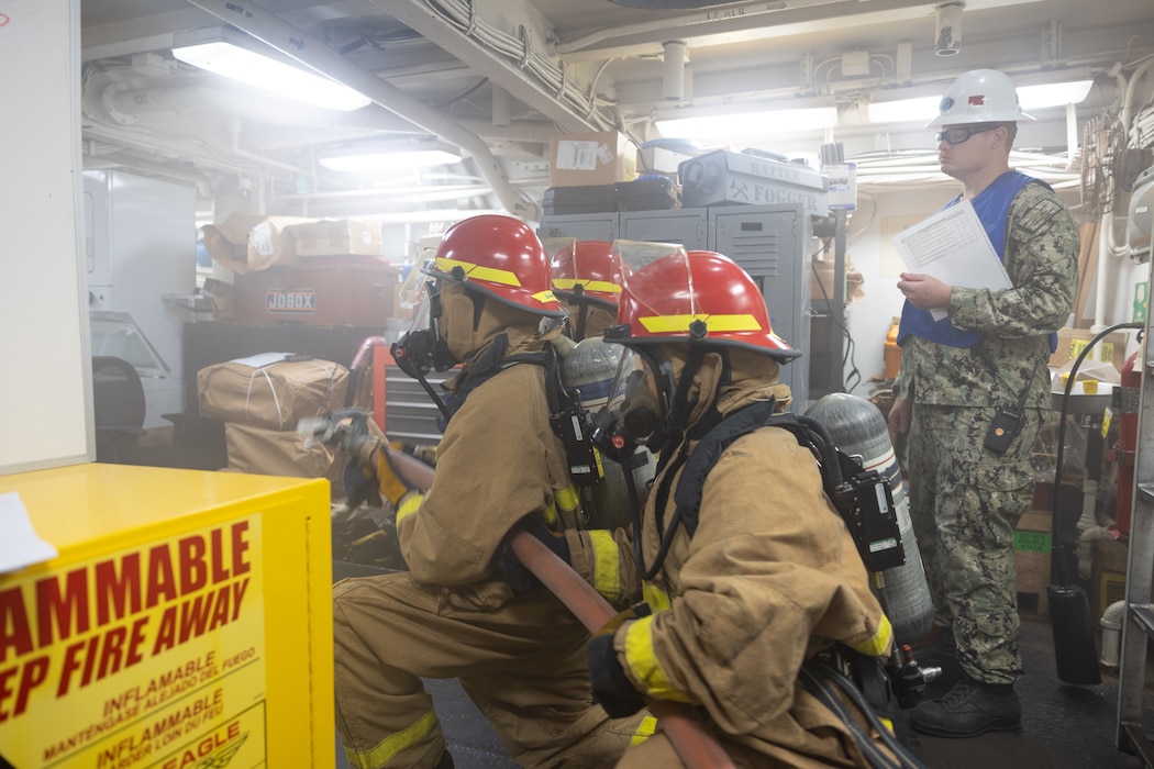 Sailors aboard USS Bataan (LHD 5) fight a simulated fire while being reviewed by Mid Atlantic Regional Maintenance Center personnel during a major fire drill.