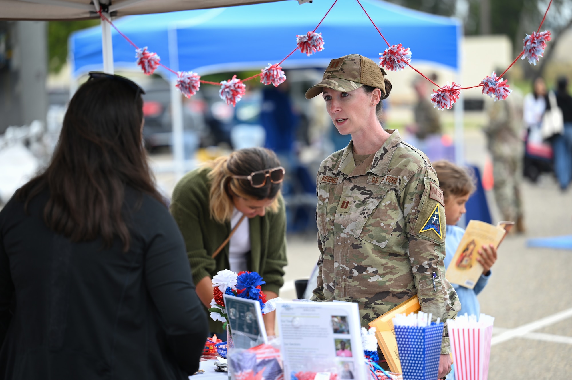 Two women talk at a booth.