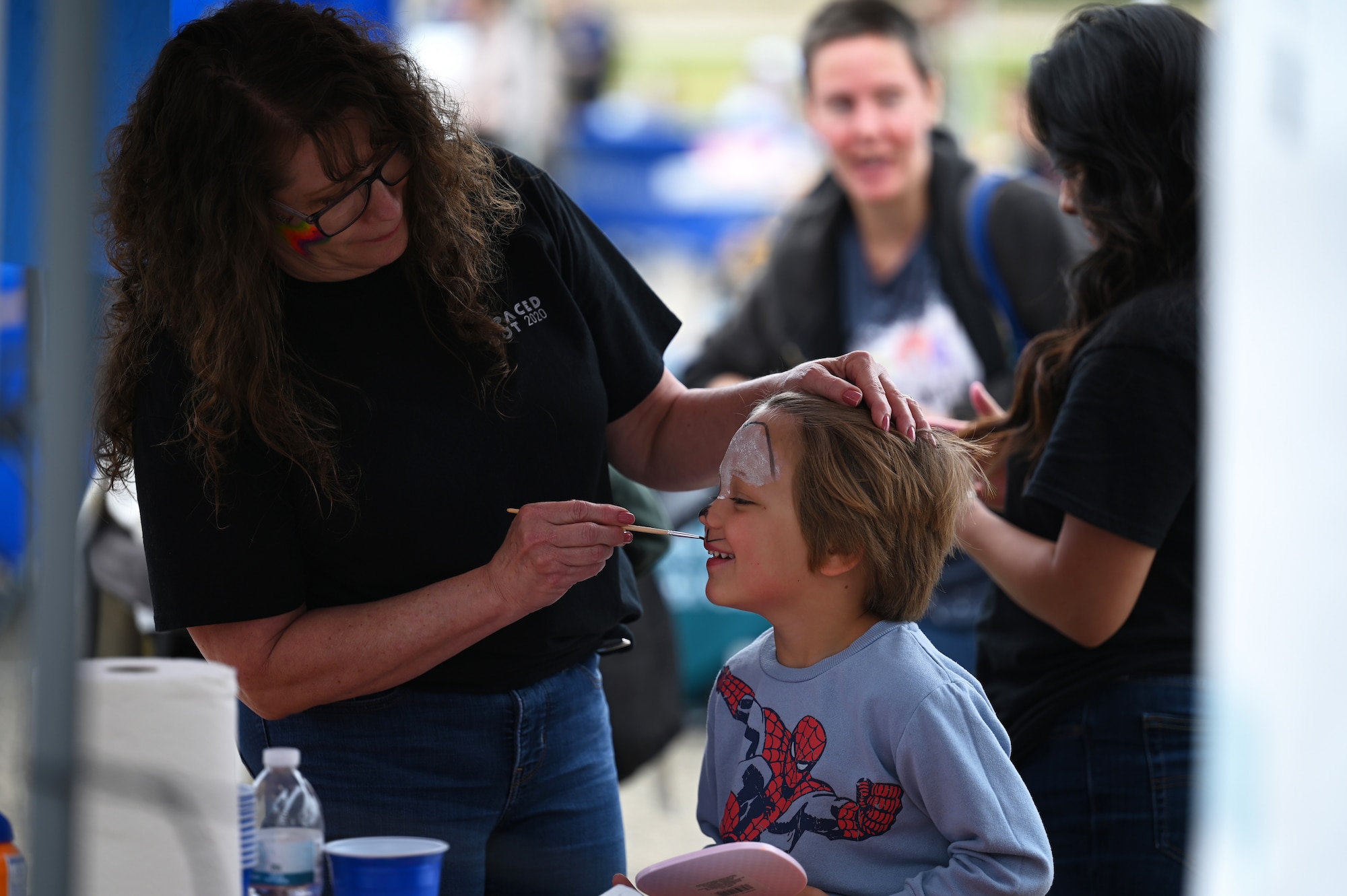 A woman paints a child's face.