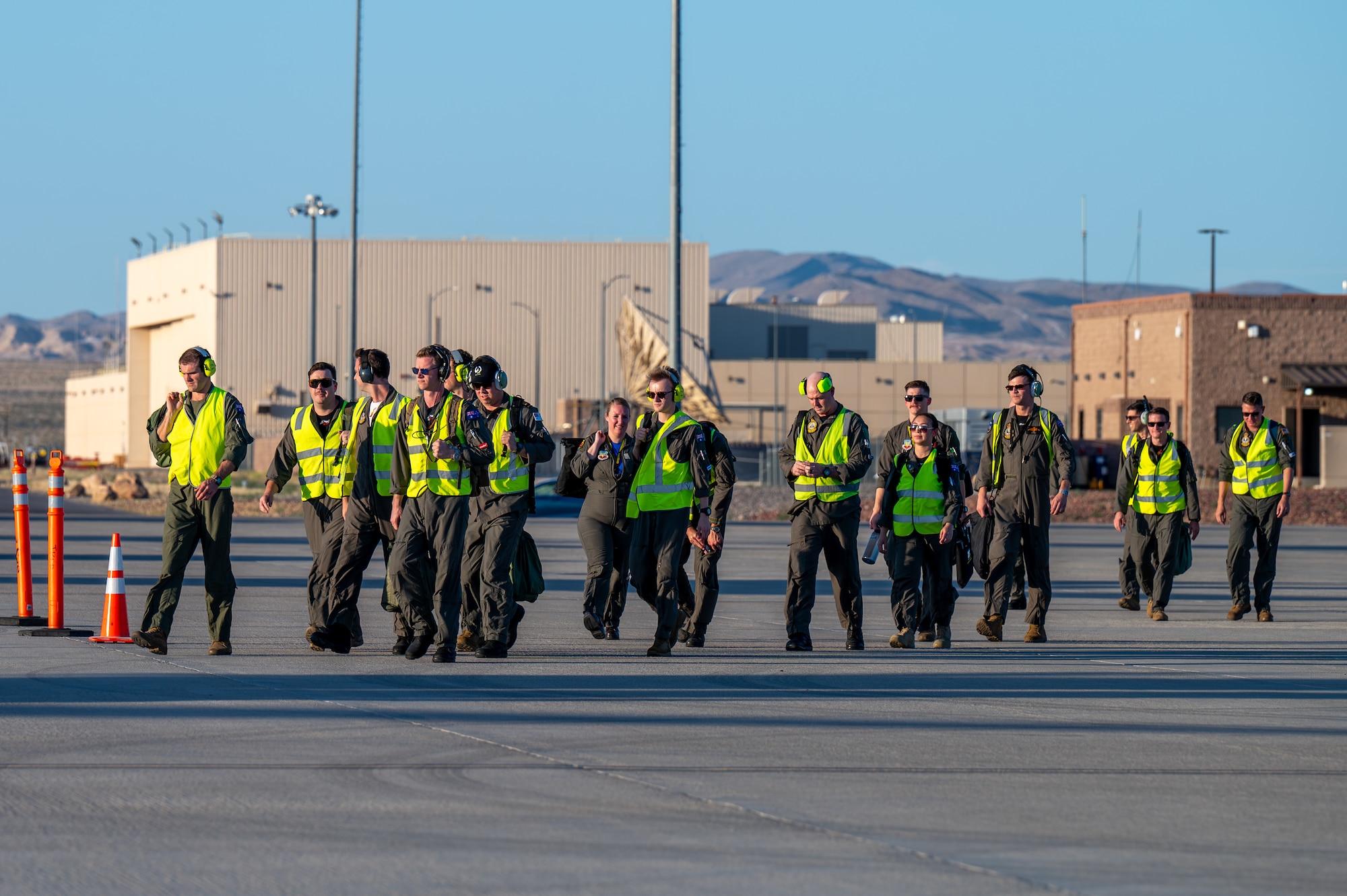 A large group of people walk on the flight line.