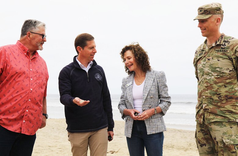 Rep. Mike Levin with California’s 49th District, second from right, shows a handful of fresh sand to Solana Beach Mayor Lesa Heebner, second from left, Encinitas Mayor Tony Kranz, left, and Col. Andrew Baker, U.S. Army Corps of Engineers Los Angeles District commander, right, during a visit to Moonlight State Beach May 13 in Encinitas, California. The new sand was placed on the beach by the U.S. Army Corps of Engineers’ contractor, Manson Construction.