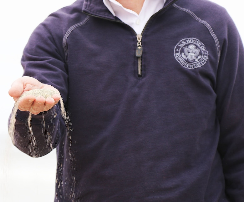 Rep. Mike Levin with California’s 49th District, displays a handful of fresh sand during a visit to Moonlight State Beach May 13 in Encinitas, California. The new sand was placed on the beach by the U.S. Army Corps of Engineers’ contractor, Manson Construction.