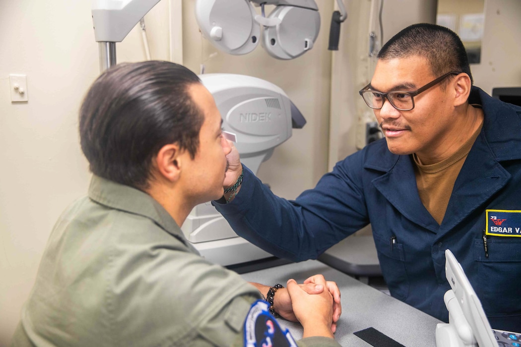 Hospitalman Apprentice Edgar D. Valdez, from Santa Rita, Guam, assigned to medical department’s MH division, measures the eyes of Hospital Corpsman 3rd Class (NAC) Daniel J. Centano, from San Antonio, assigned to Helicopter Sea Combat Squadron (HSC) 5’s medical division, aboard Nimitz-class aircraft carrier USS George Washington (CVN 73) while underway in the Pacific Ocean, June 12, 2024.  George Washington is deployed as part of Southern Seas 2024 which seeks to enhance capability, improve interoperability, and strengthen maritime partnerships with countries throughout the U.S. Southern Command area of responsibility through joint, multinational, and interagency exchanges and cooperation. (U.S. Navy photo by Mass Communication Specialist Seaman Kiejuanesha Simmons)
