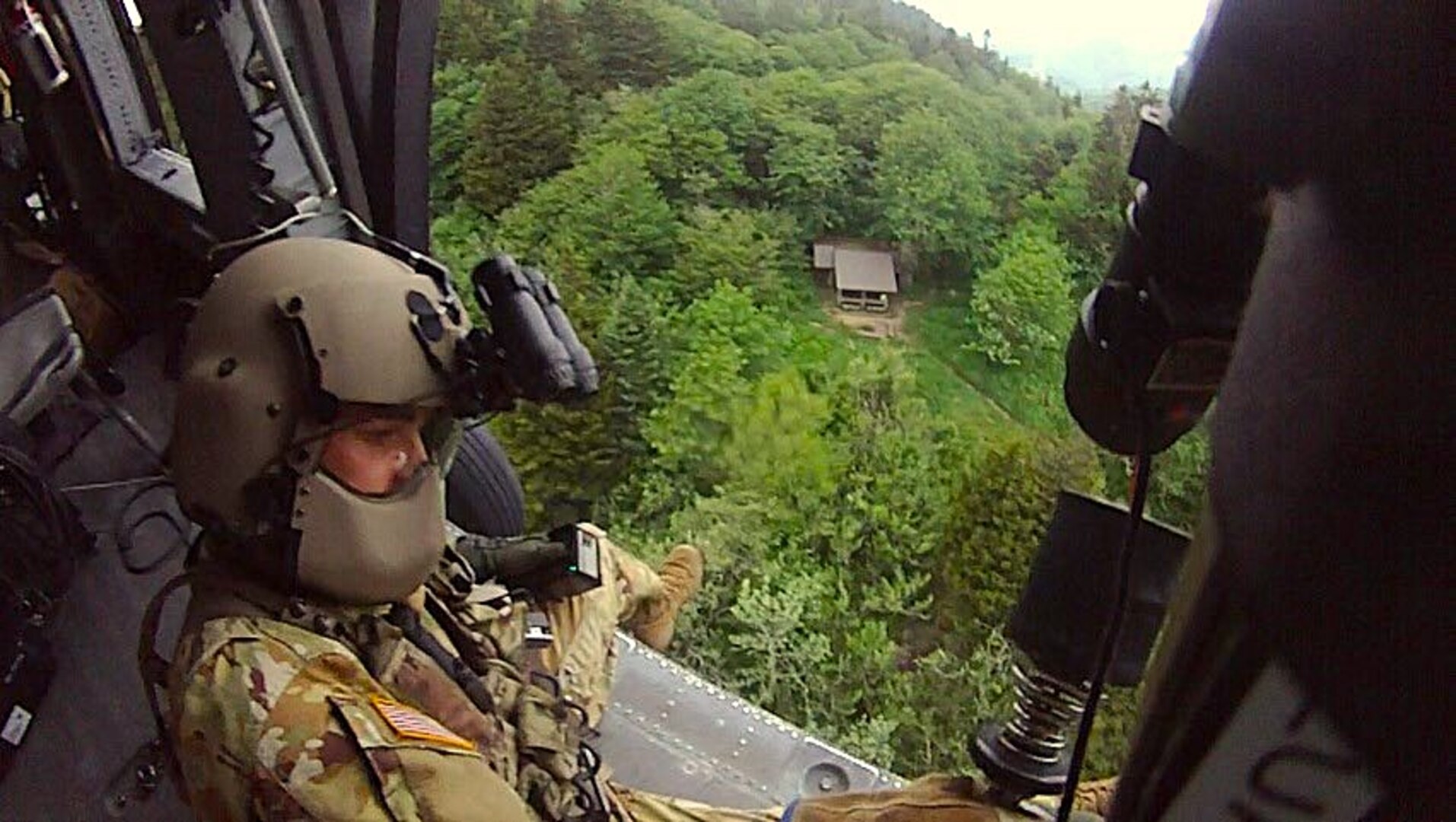 Tennessee Army National Guard Black Hawk helicopter crew chief Sgt. Daniel Bandy prepares to lower flight paramedic Sgt. 1st Class Giovanni DeZuani by hoist to rescue a hiker in cardiac distress at the Double Spring Gap Shelter in the Great Smoky Mountains National Park June 12, 2024.