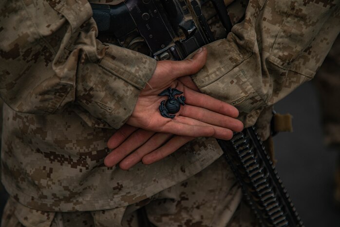 A U.S. Marine with Bravo Company, 1st Recruit Training Battalion, Recruit Training Regiment holds an Eagle, Globe and Anchor emblem during an EGA ceremony on Marine Corps Base Camp Pendleton, California, June 5, 2024. The EGA ceremony was the final event of the Crucible and represents the transformation of recruit to Marine. (U.S. Marine Corps photo by Cpl. Elliott A. Flood-Johnson)