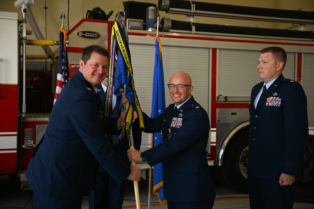U.S. Air Force Col. Timothy Dalby, 17th Mission Support Group commander, left, receives the guidon from Lt. Col. Joshua Carroll, outgoing 17th Civil Engineering Squadron commander, center, during the 17th CES change of command ceremony at the Goodfellow Fire Department, Goodfellow Air Force Base, Texas, June 13, 2024. The passing of the guidon to Dalby signifies Carroll’s relinquishment of command of the 17th CES. (U.S. Air Force photo by Airman 1st Class Evelyn J. D’Errico)