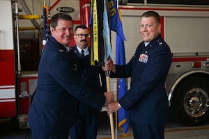U.S. Air Force Col. Timothy Dalby, 17th Mission Support Group commander, left, passes the guidon to Maj. Levi Beard, incoming 17th Civil Engineering Squadron commander, right, during the 17th CES change of command ceremony at the Goodfellow Fire Department, Goodfellow Air Force Base, Texas, June 13, 2024. The passing of the guidon to Levi signifies him taking command of the 17th CES. (U.S. Air Force photo by Airman 1st Class Evelyn J. D’Errico)