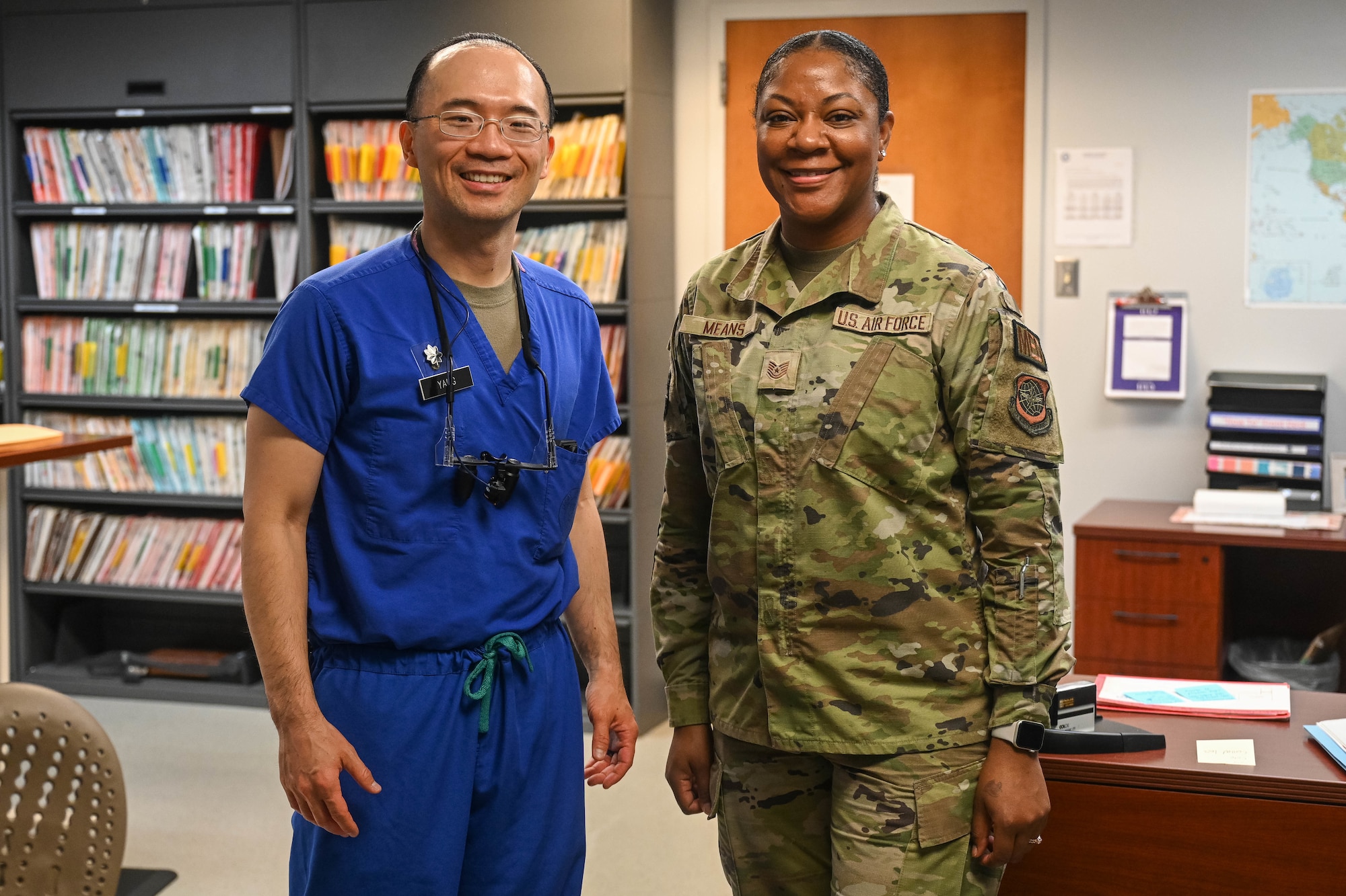 A man and a woman smile as they stand in a dental records office.