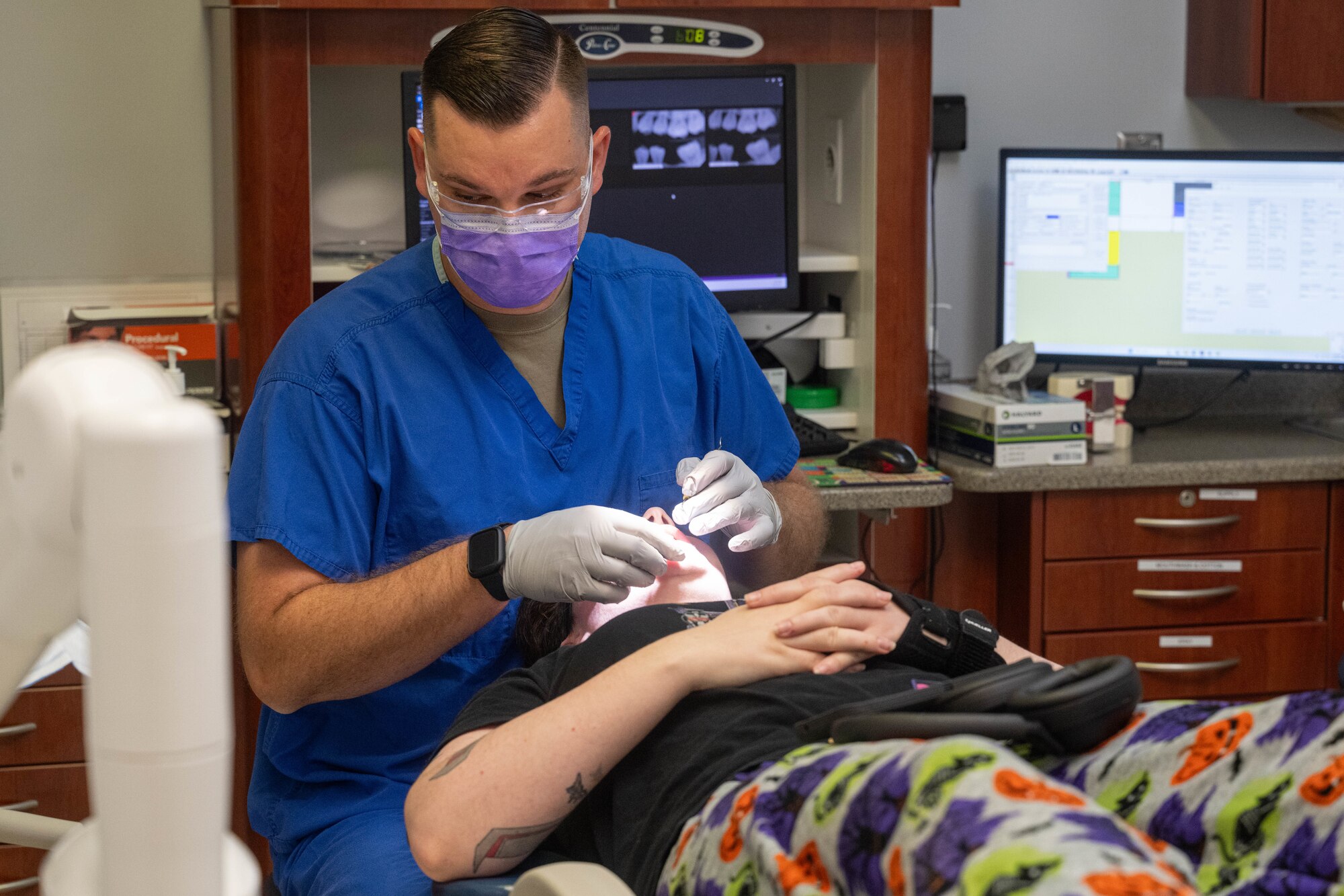 A man provides dental care to a patient
