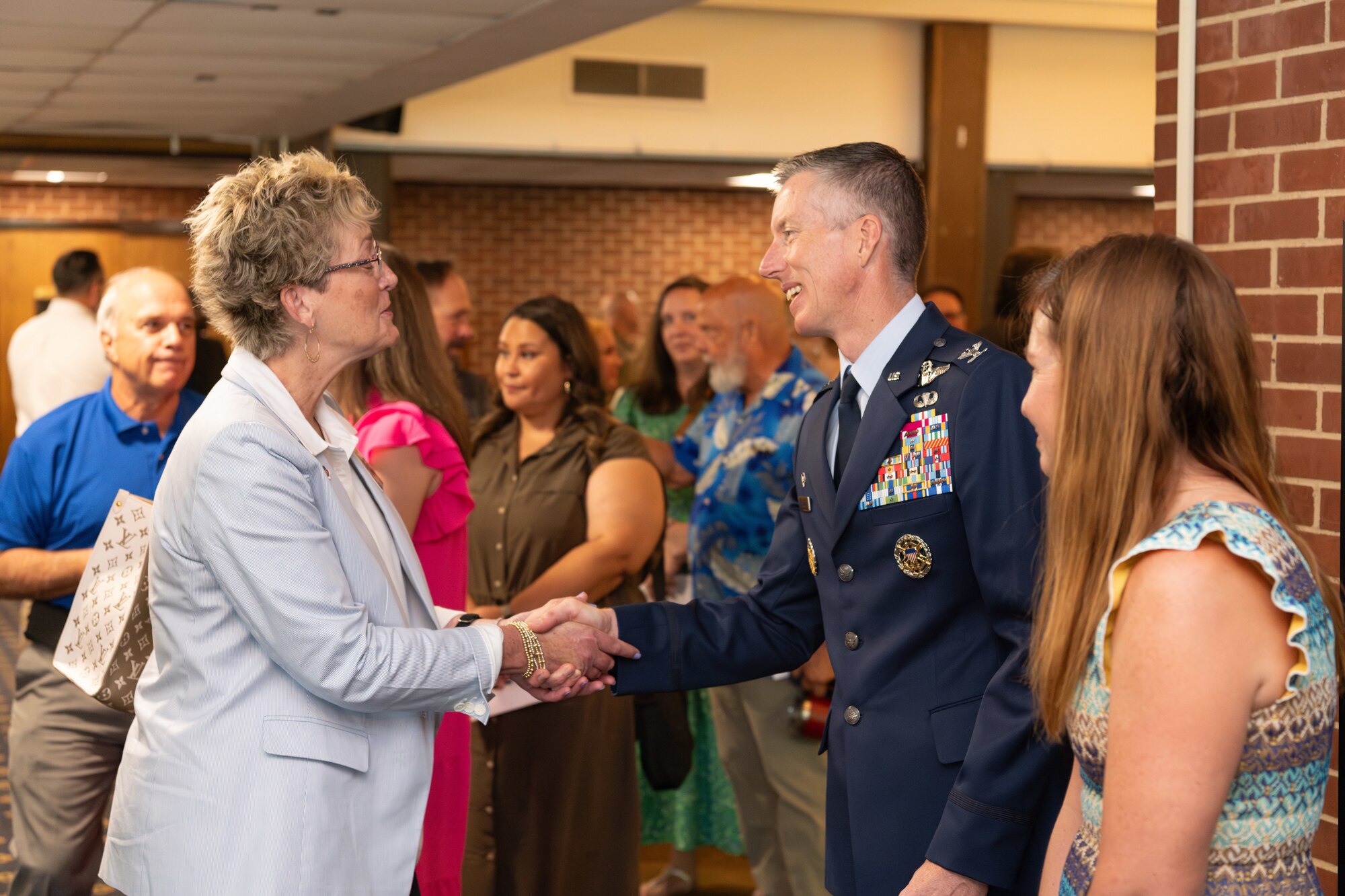 New Arnold Engineering Development Complex Commander Col. Grant Mizell and his wife Evelyn, right, are welcomed by Dr. Catherine Stephens, superintendent of Tullahoma City Schools and AEDC Honorary Commander, following a June 13, 2024, Change of Command ceremony at Arnold Lakeside Center on Arnold Air Force Base, Tenn., headquarters of AEDC. During the ceremony, Mizell accepted the guidon to become the 33rd commander of AEDC. (U.S. Air Force photo by Keith Thornburgh)