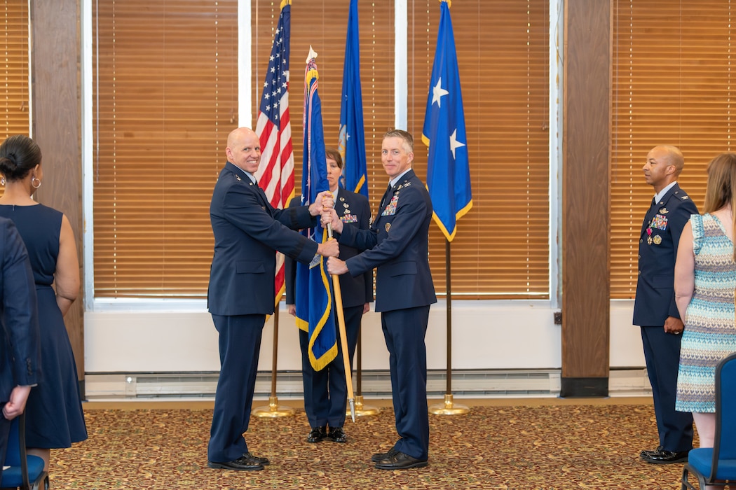 Col. Grant Mizell, right center, accepts the guidon from Air Force Test Center Commander Maj. Gen. Evan Dertien to assume command of Arnold Engineering Development Complex during a Change of Command ceremony June 13, 2024, at the Arnold Lakeside Complex on Arnold Air Force Base, Tenn., headquarters of AEDC. Also pictured are outgoing AEDC Commander Col. Randel Gordon, right, and AEDC Senior Enlisted Leader Chief Master Sgt. Jennifer Cirricione, center. (U.S. Air Force photo by Keith Thornburgh)