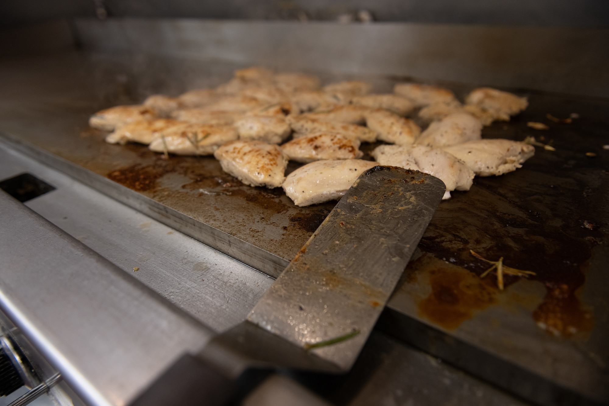 Chicken sizzles on grill.