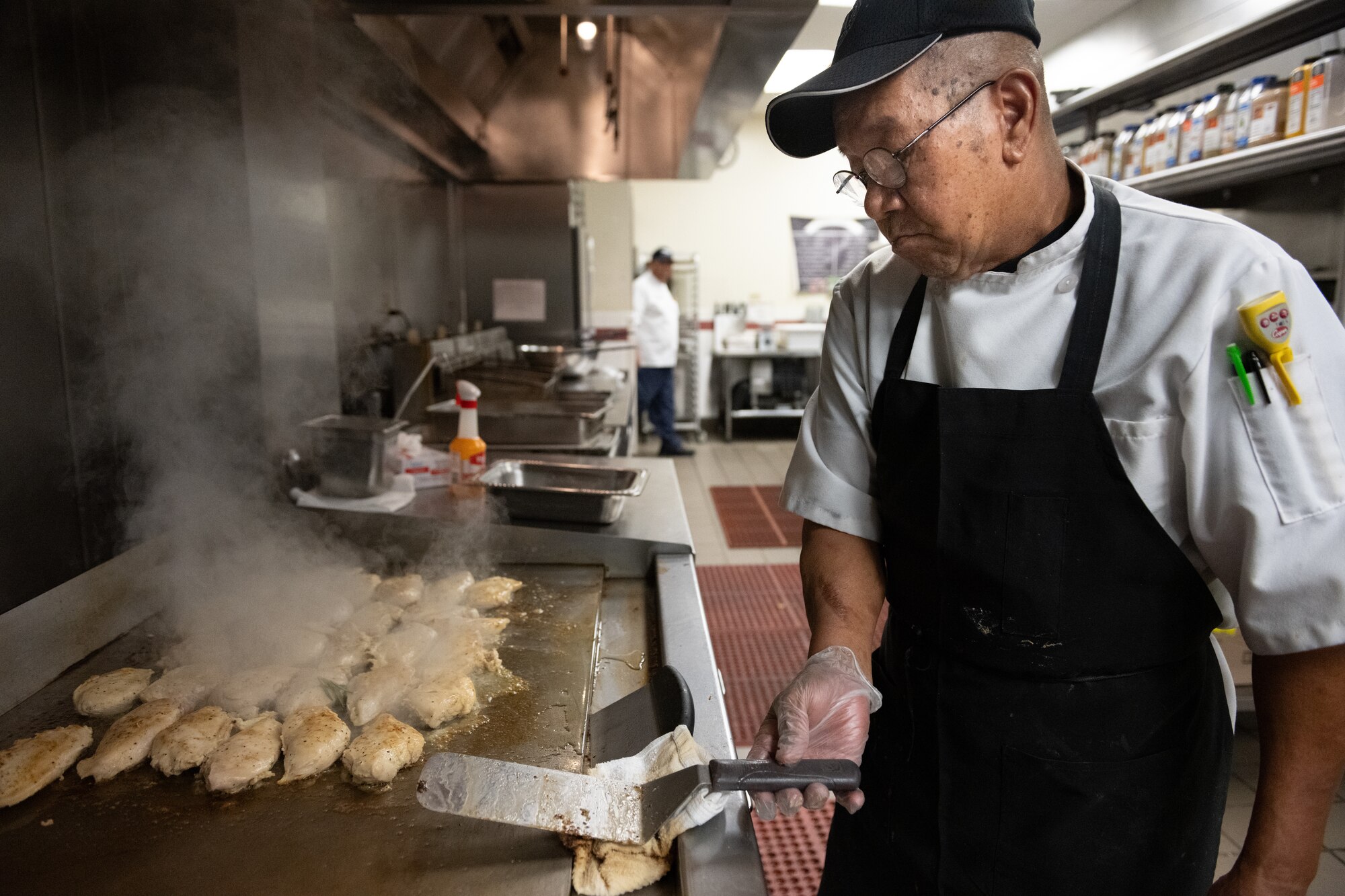 Civilian cook prepares chicken
